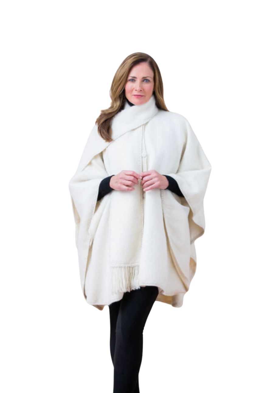 Woman in an ivory lined alpaca cape with scarf, standing