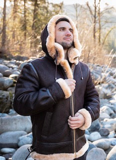 Hooded sheepskin bomber jacket with shearling cuffs, on model outdoors