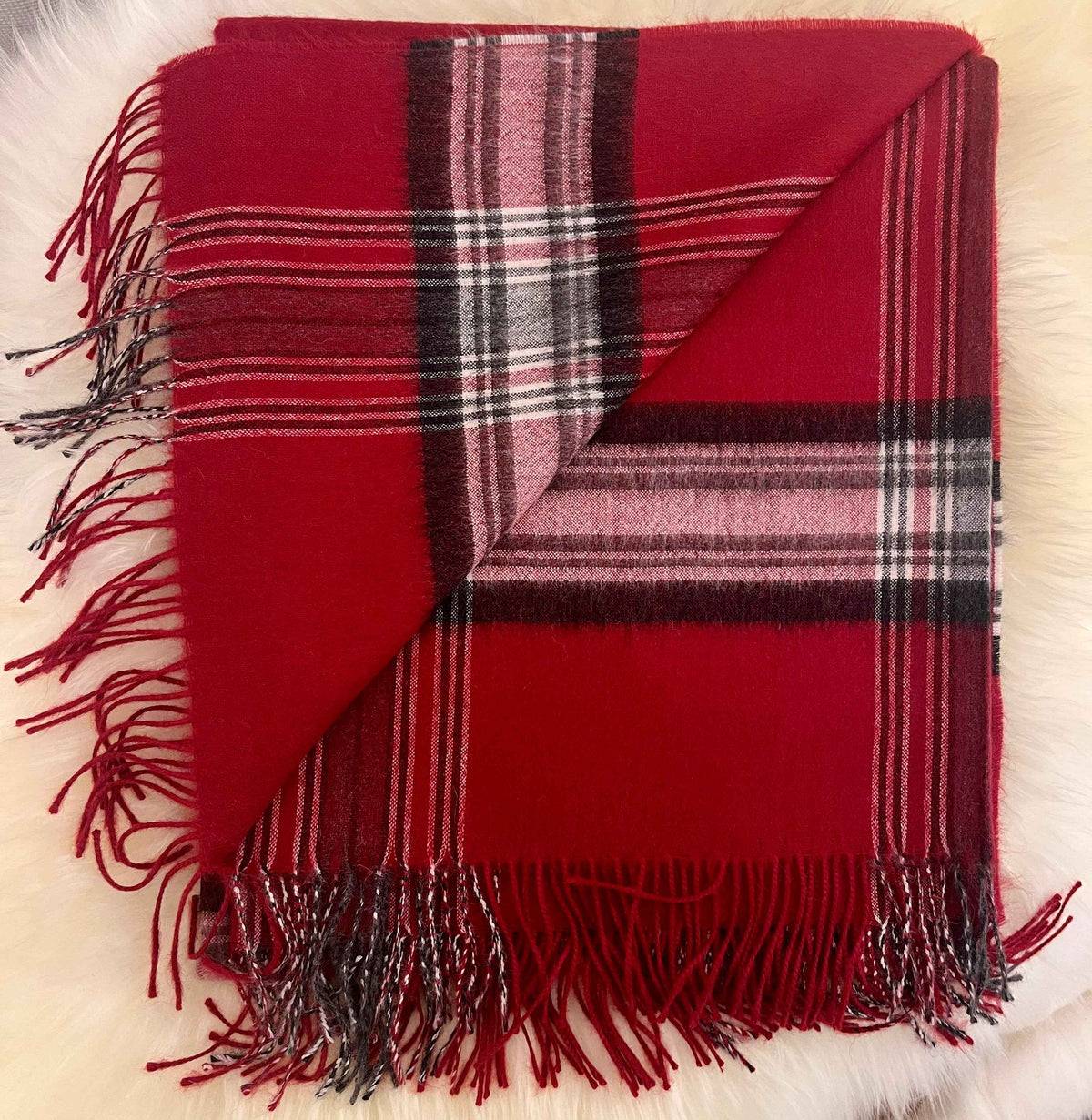 Folded red plaid baby alpaca throw with fringe