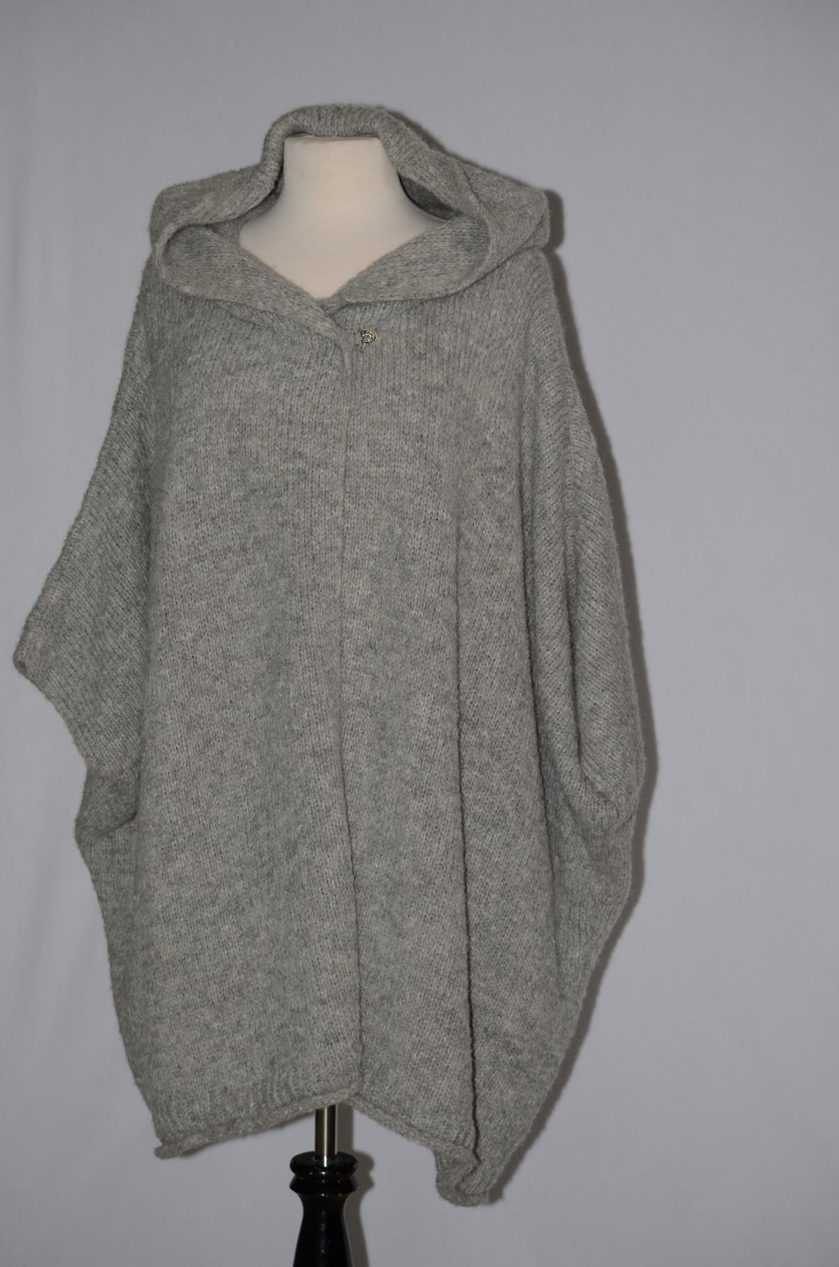Gray baby alpaca hooded poncho on a dress form, front view