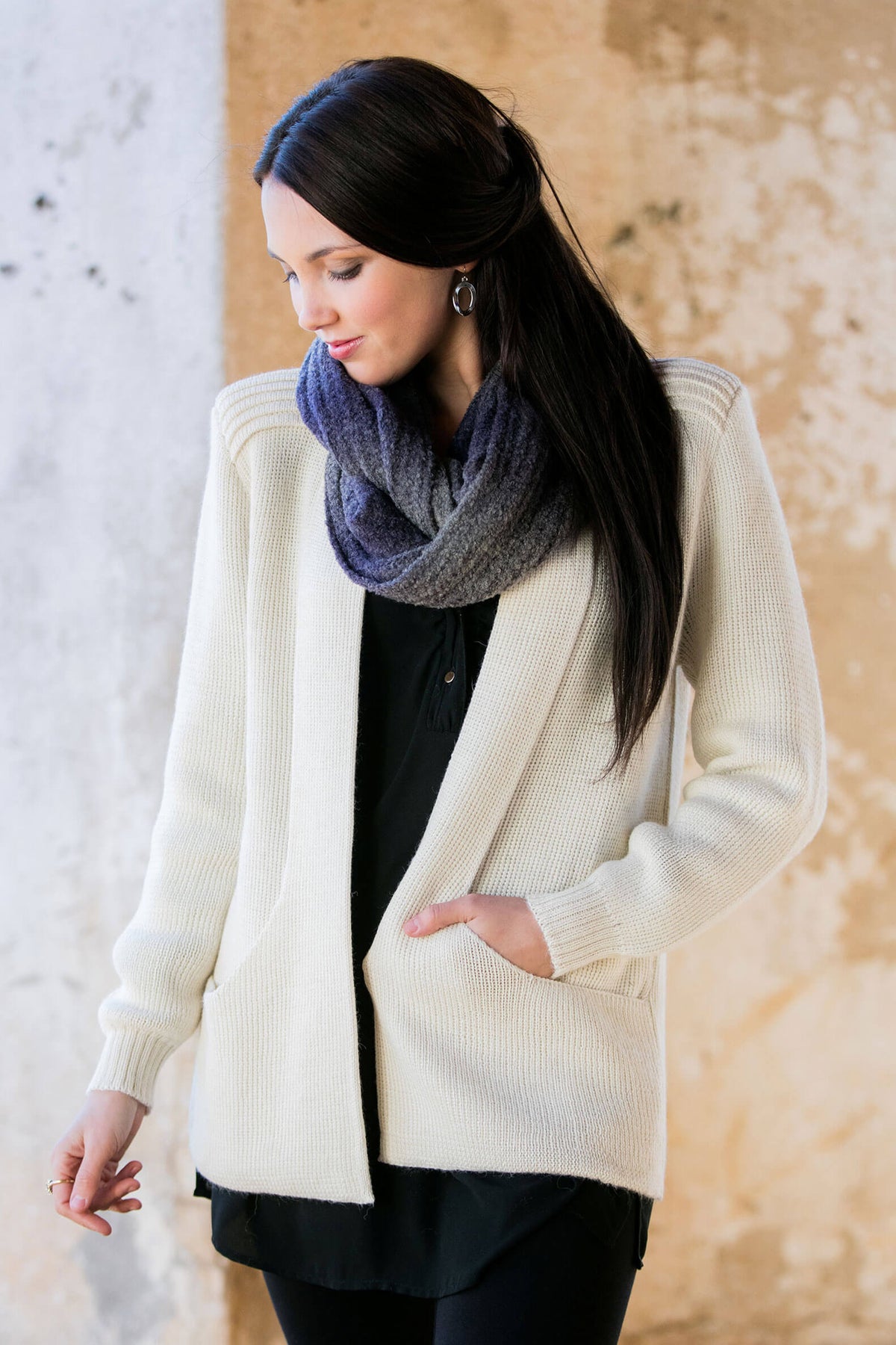 Woman wearing an ivory alpaca cardigan sweater, front view