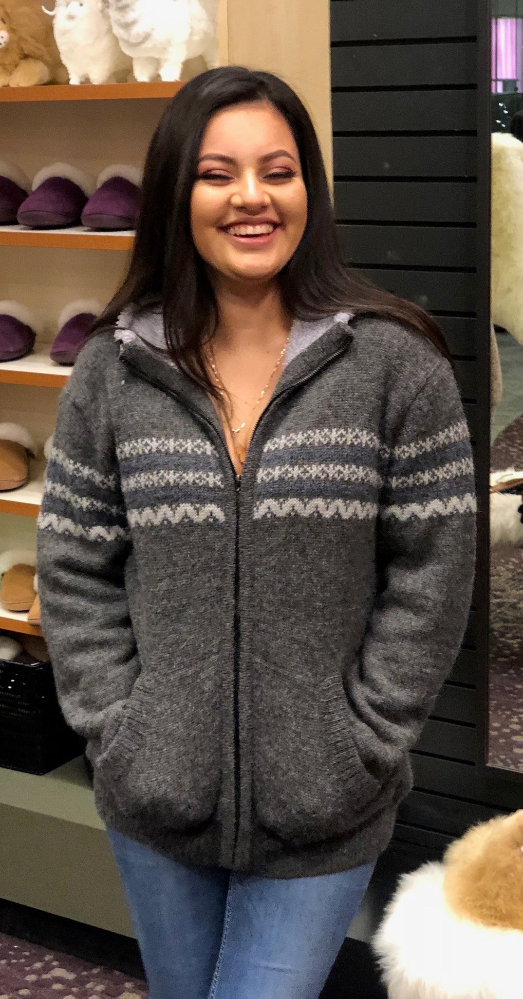 Woman wearing a gray fleece-lined alpaca zip sweater, hands in pockets