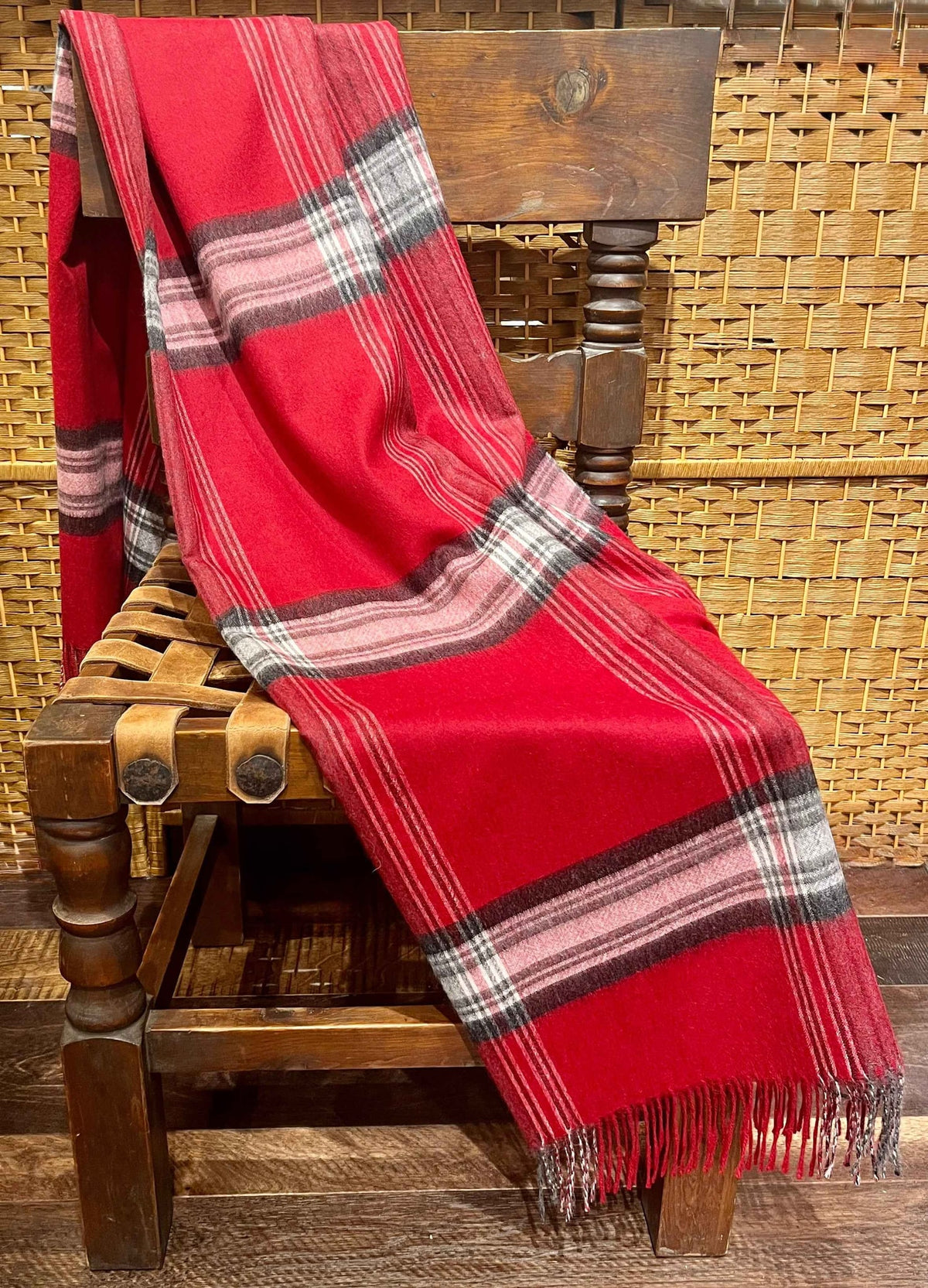 Red plaid baby alpaca throw draped over a wooden chair