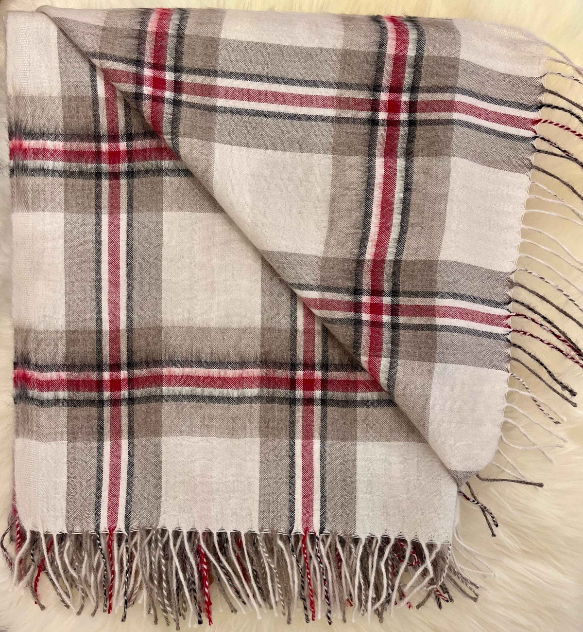 Folded ivory and red tartan plaid alpaca throw with fringe