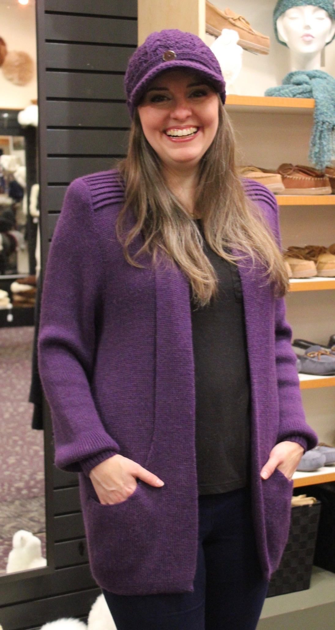 Woman wearing a purple alpaca cardigan sweater in the shop