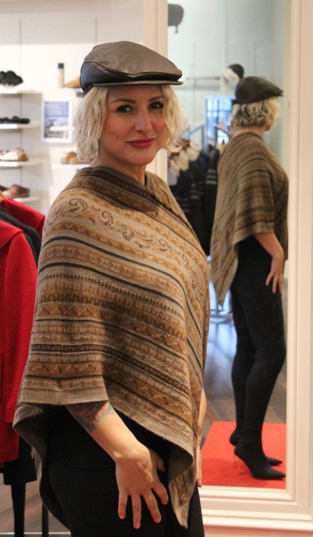 Woman wearing a brown striped alpaca Sedona poncho and cap