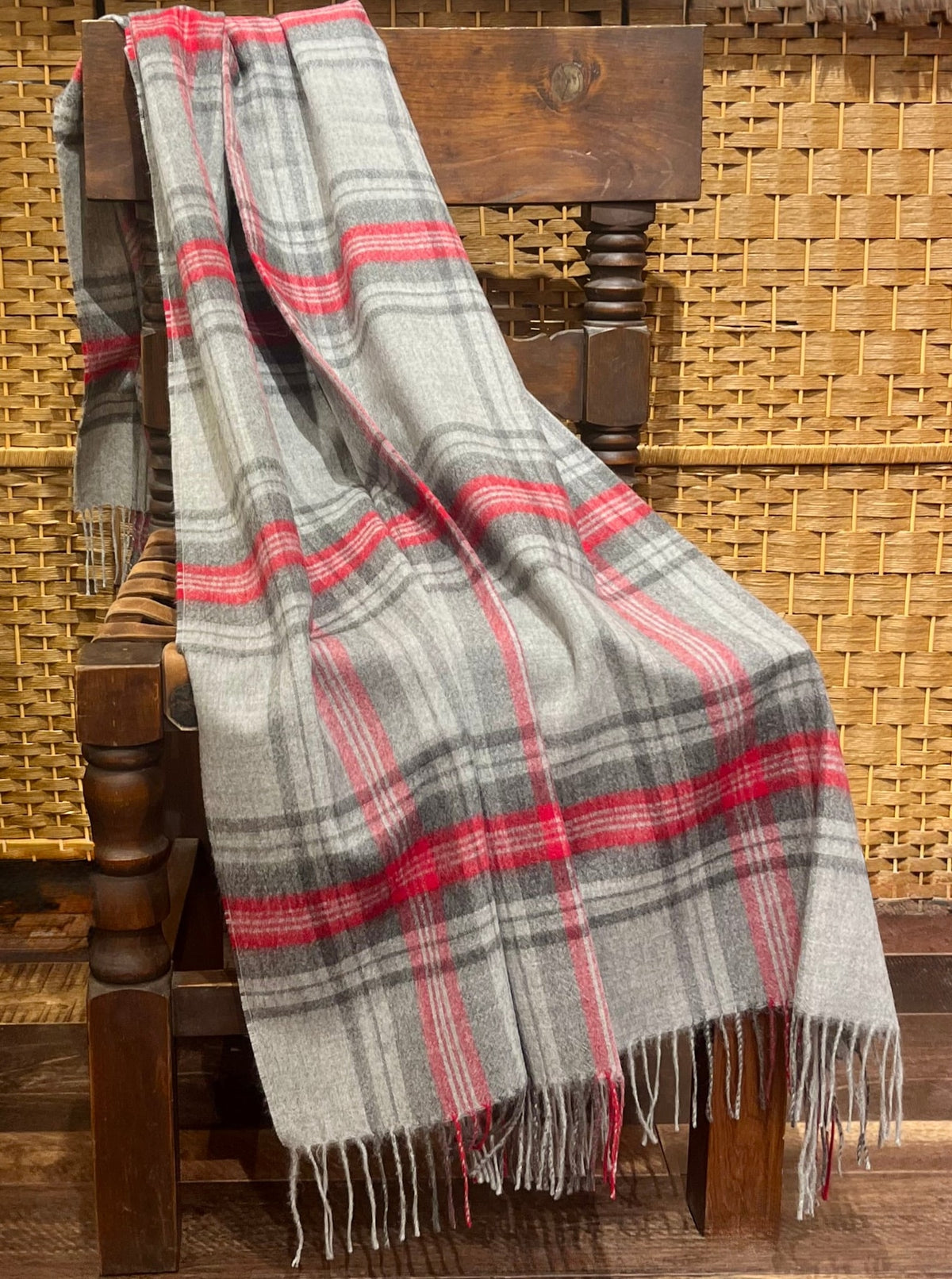 Grey and red tartan plaid alpaca throw draped over a chair