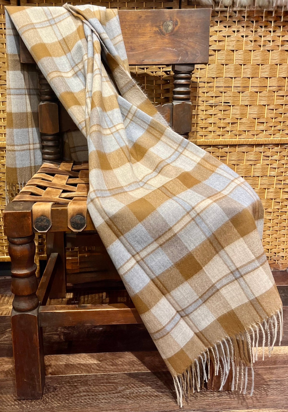 Toffee tartan plaid alpaca throw draped over a wooden chair
