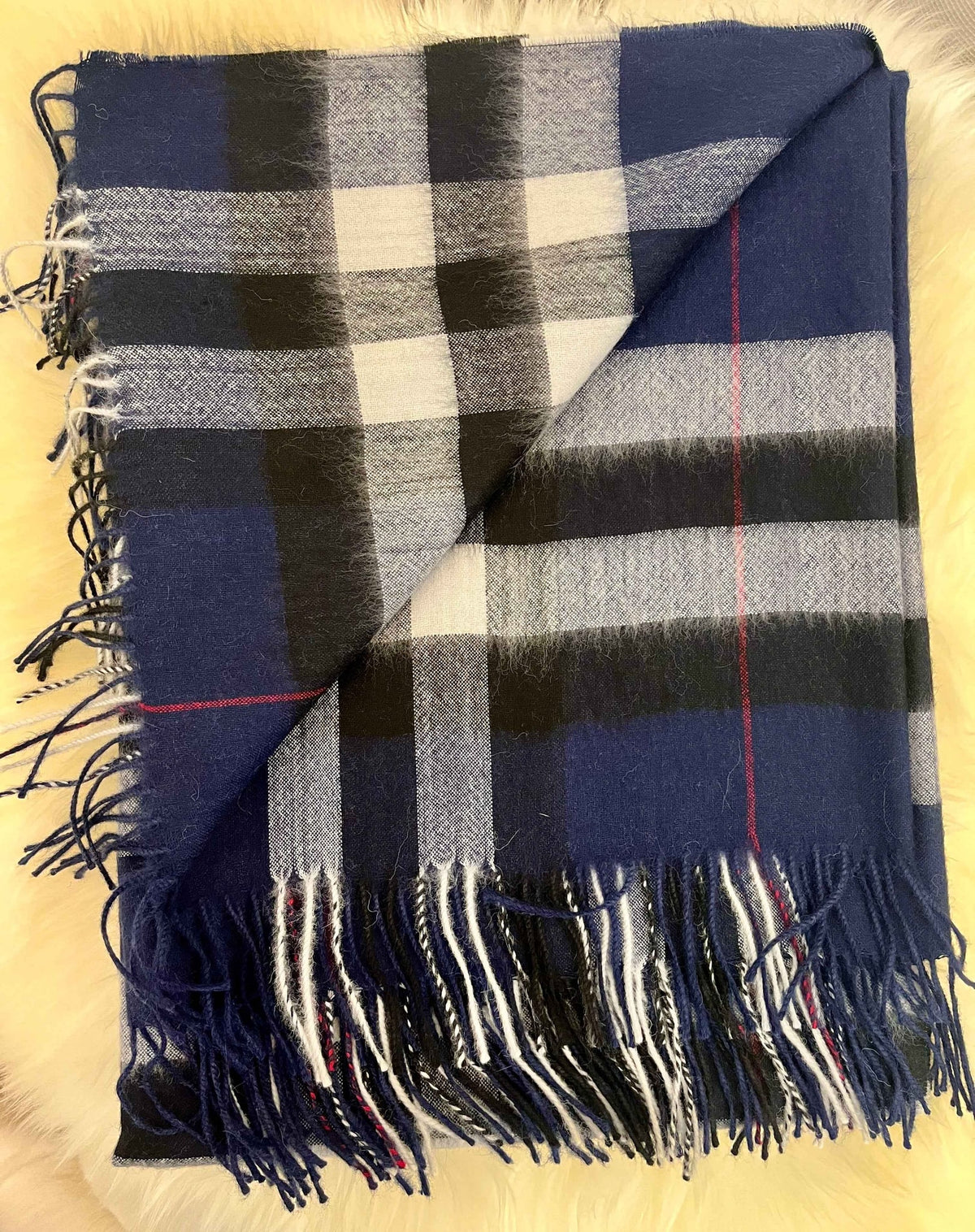 Folded navy plaid baby alpaca throw with fringe