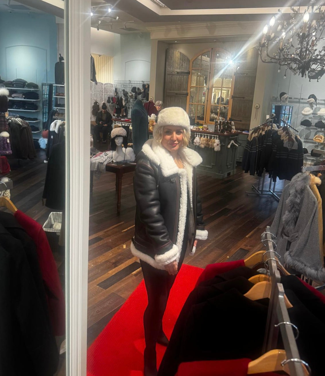 Man wearing a sheepskin bomber jacket with shearling trim in the shop
