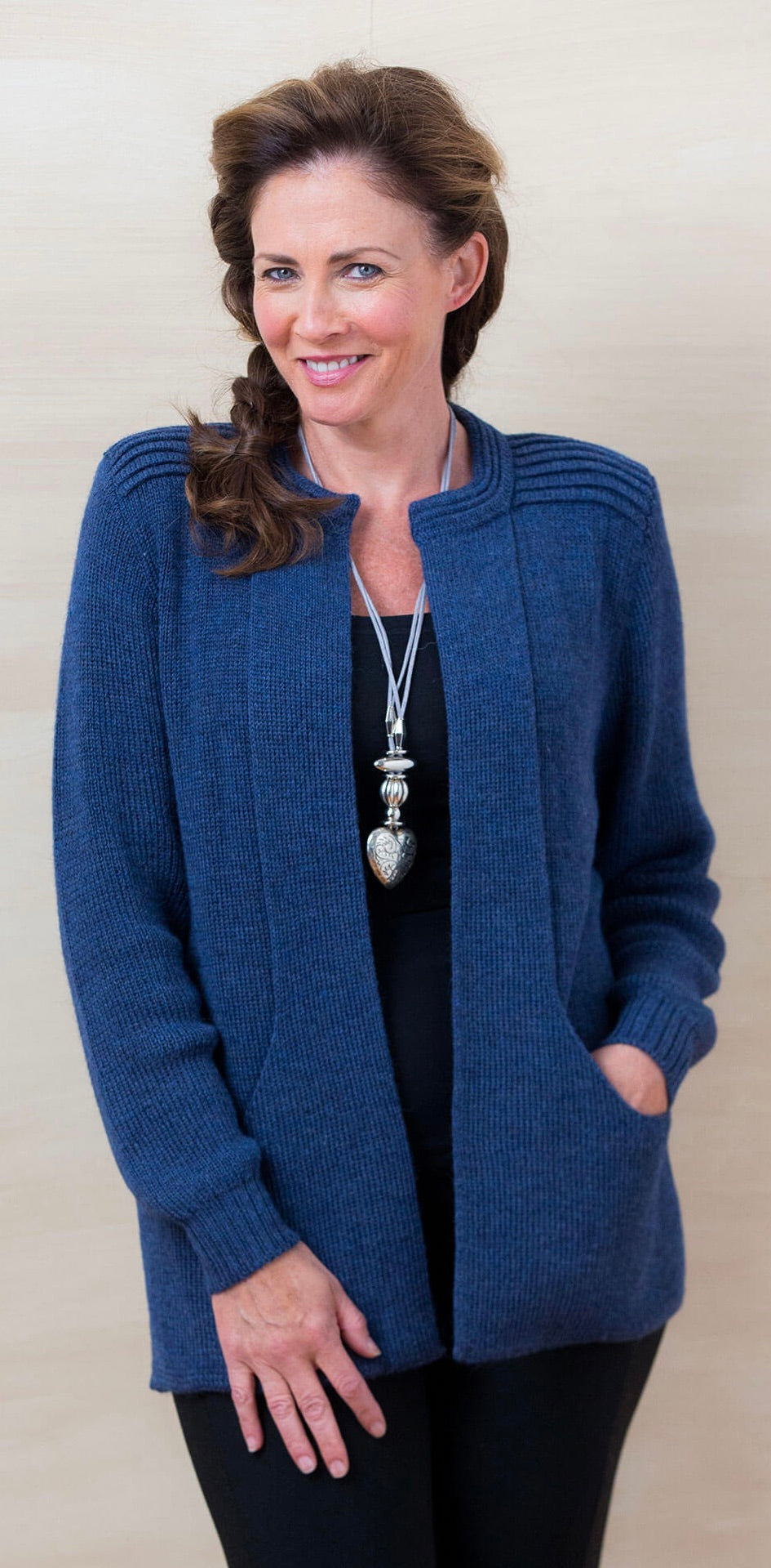 Woman wearing a true blue alpaca cardigan sweater with pockets