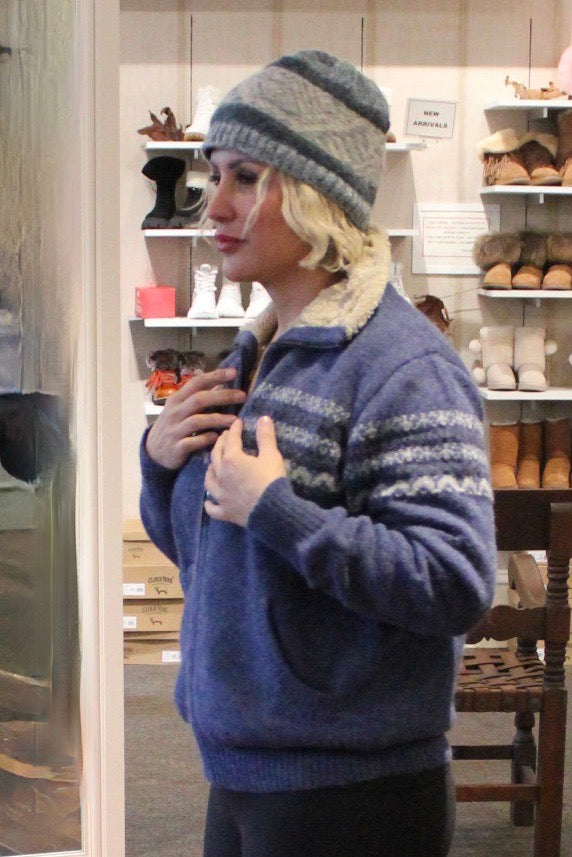Woman in a blue fleece-lined alpaca zip sweater and knit hat