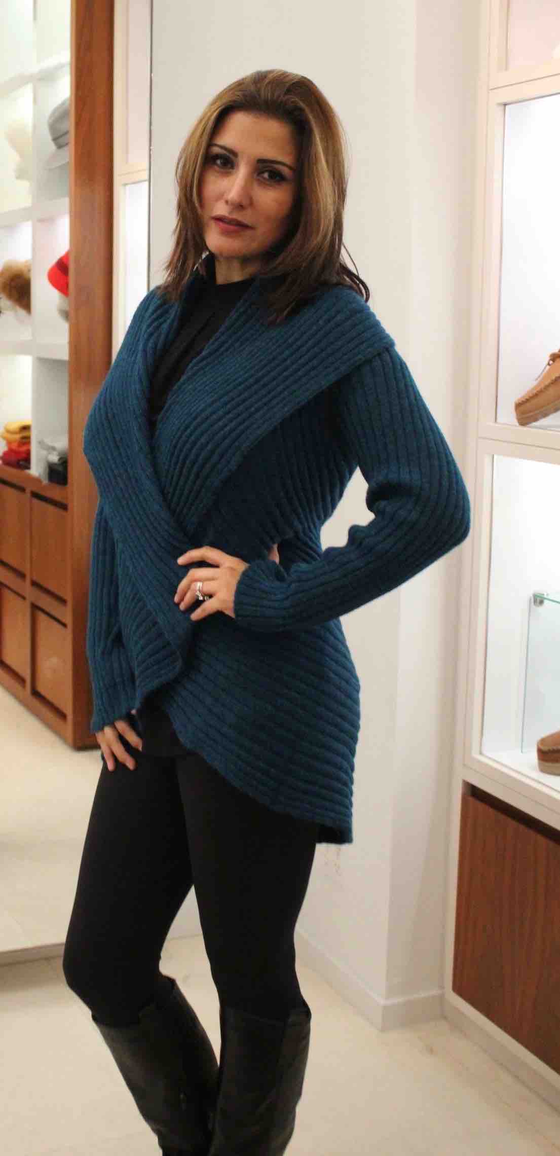 Woman wearing a blue alpaca draped cardigan sweater in store