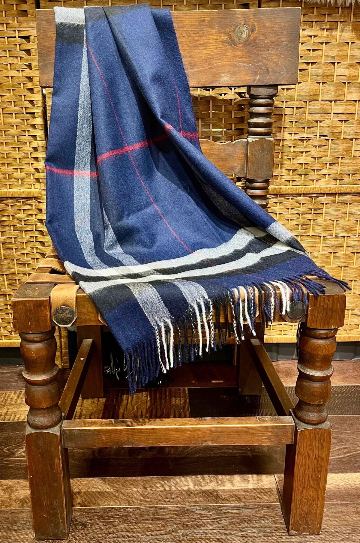 Navy plaid baby alpaca throw draped over a wooden chair