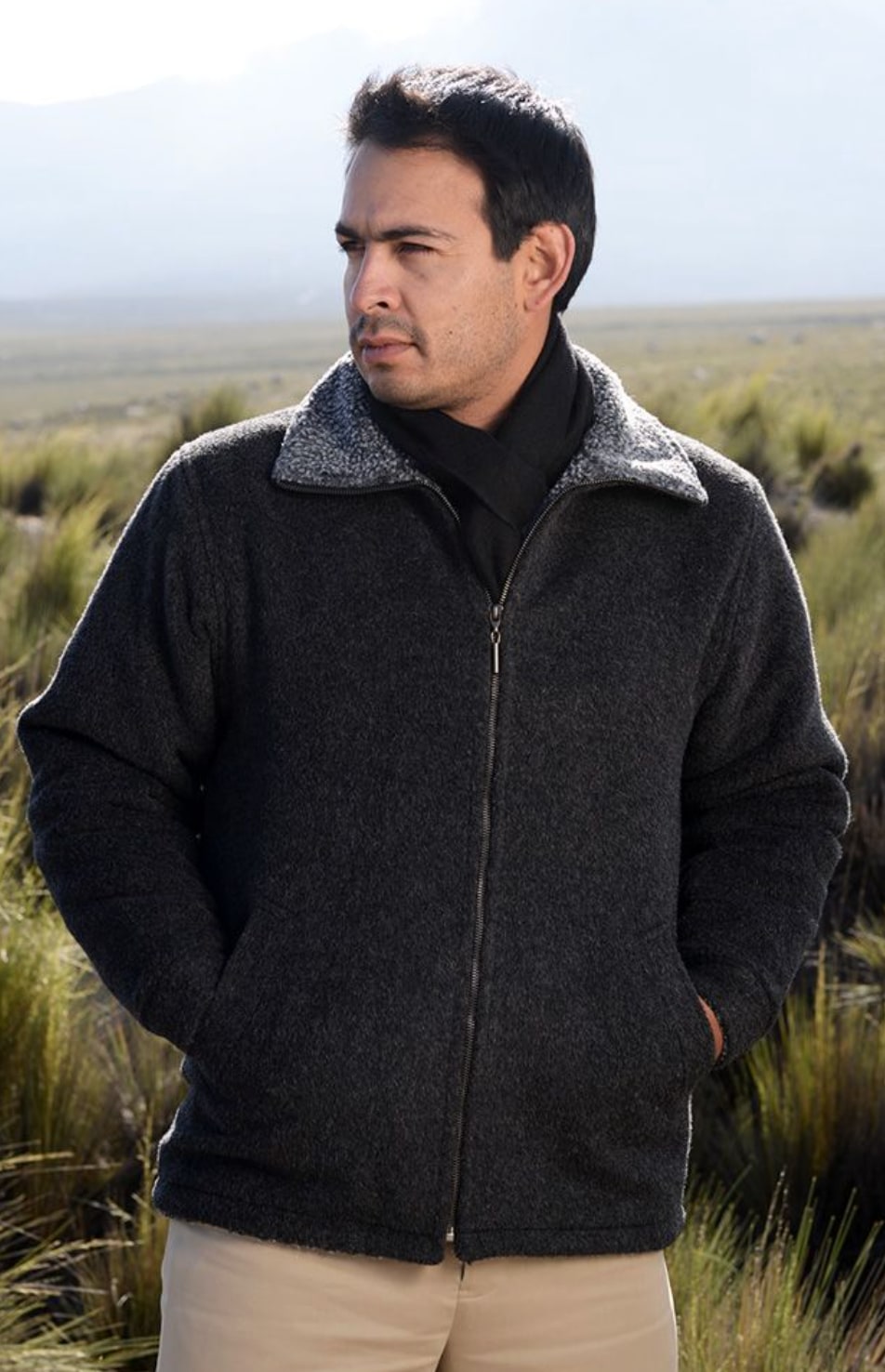 Man wearing a charcoal alpaca barn coat outdoors in tall grass