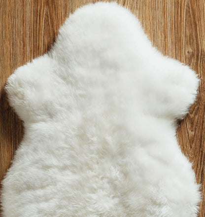 Single white sheepskin pelt laid on a wood floor