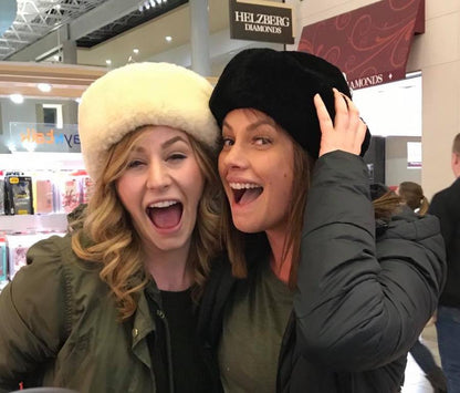 Two Girls Excited to show off their Snowball Sheepskin hats