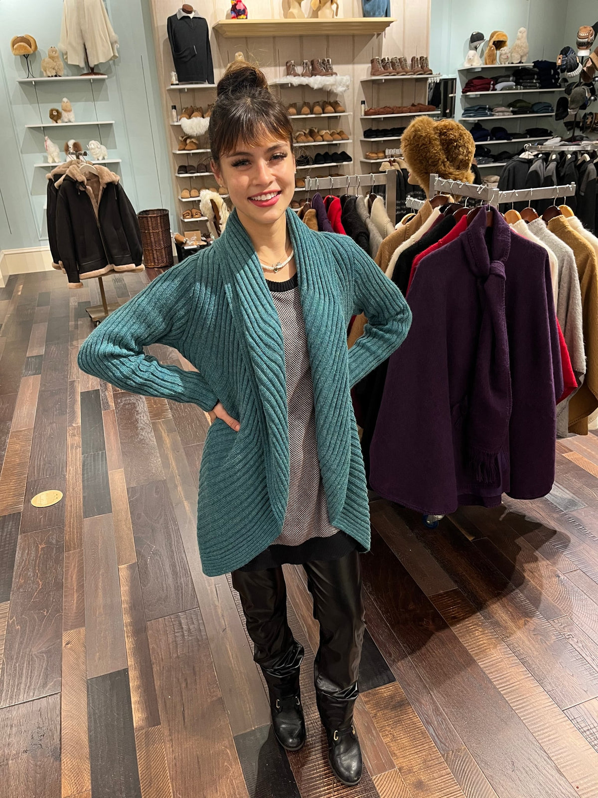 Woman in a teal alpaca round sweater in the shop